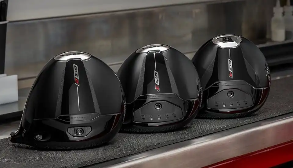Three black Titleist driver heads displayed on a shelf